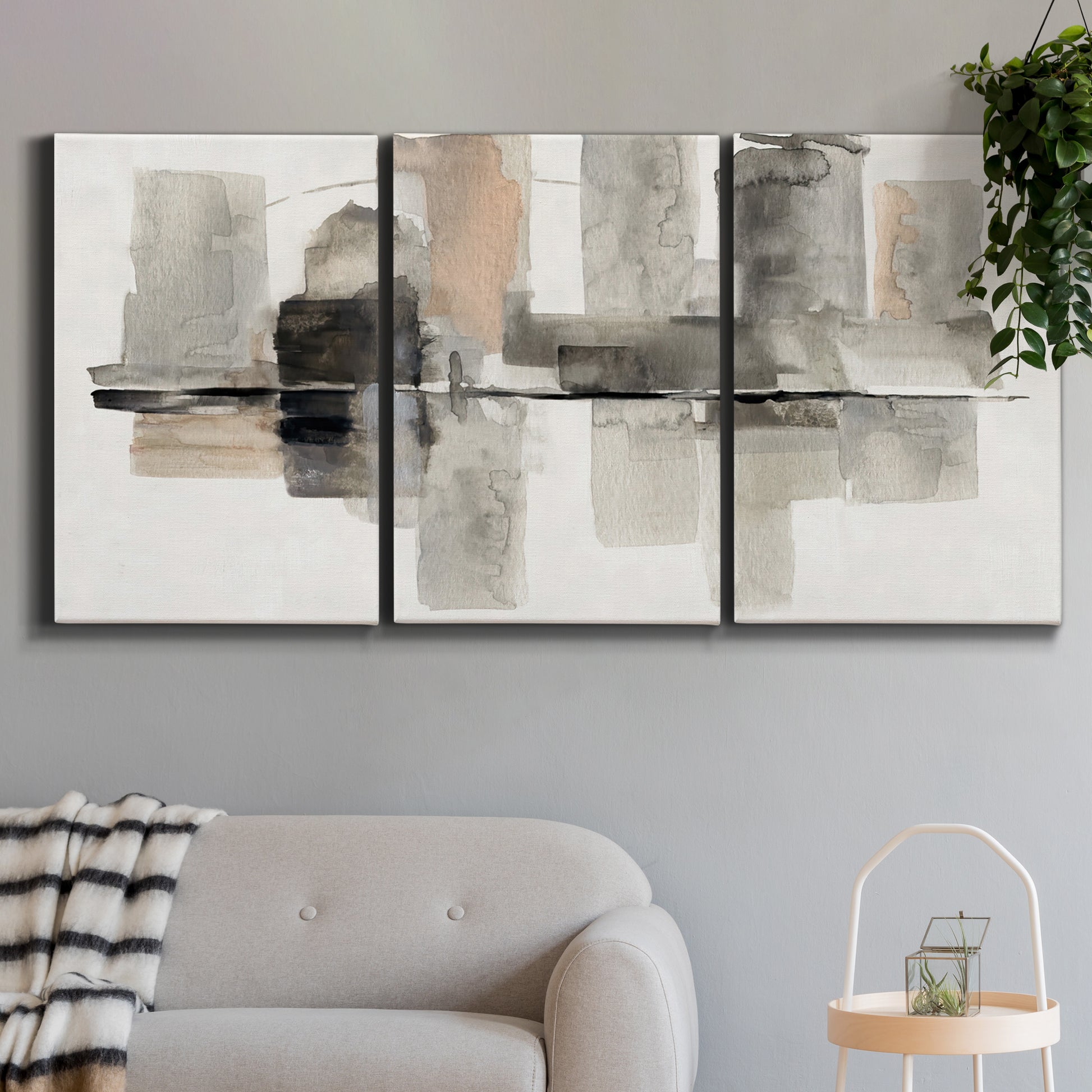 Three-panel canvas wall art featuring urban abstract watercolor oasis, displayed in a modern living room above a sofa.