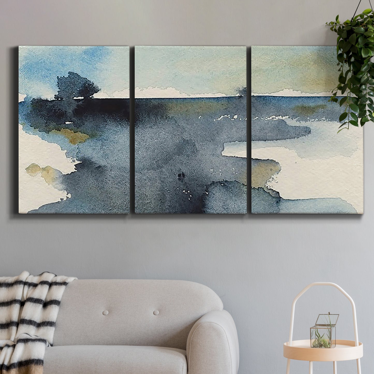 Three-panel canvas wall art featuring abstract watercolor with upward motion, displayed in a modern living room above a sofa.