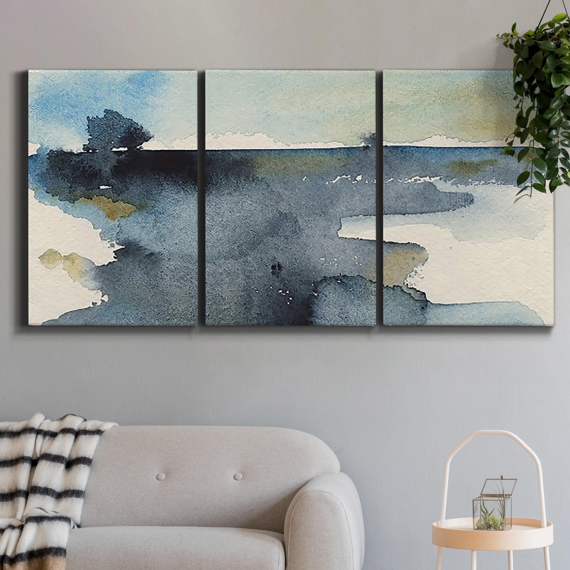 Three-panel canvas wall art featuring abstract watercolor with upward motion, displayed in a modern living room above a sofa.