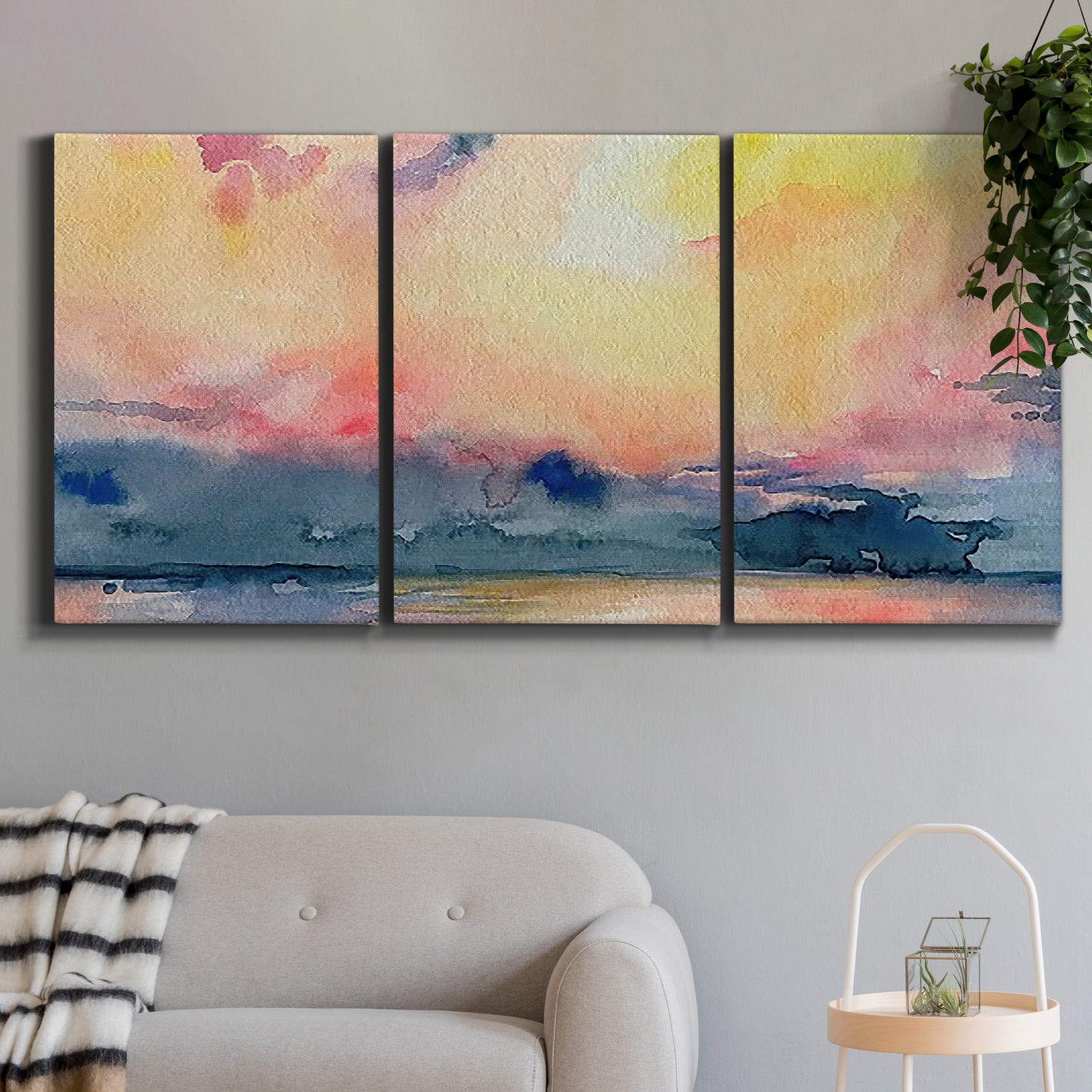 Three-panel canvas wall art featuring prismatic watercolor coastal seascape, displayed in a modern living room above a sofa.