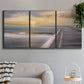 Three-panel canvas wall art featuring tropical beach at sunset photograph, displayed in a modern living room above a sofa.