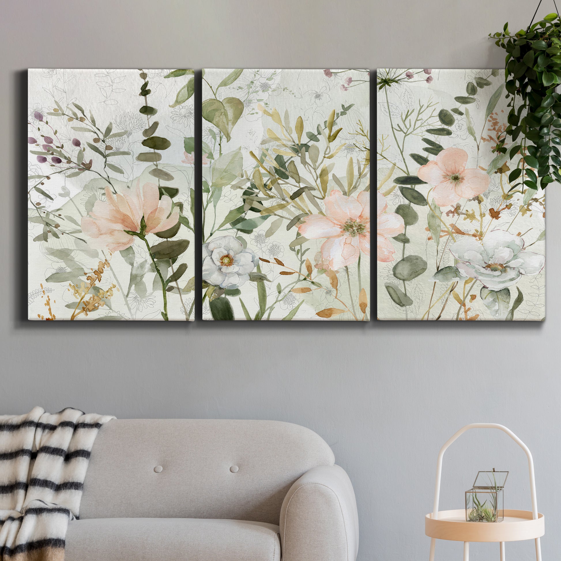 Three-panel canvas wall art featuring vintage floral botanical sketchbook, displayed in a modern living room above a sofa.