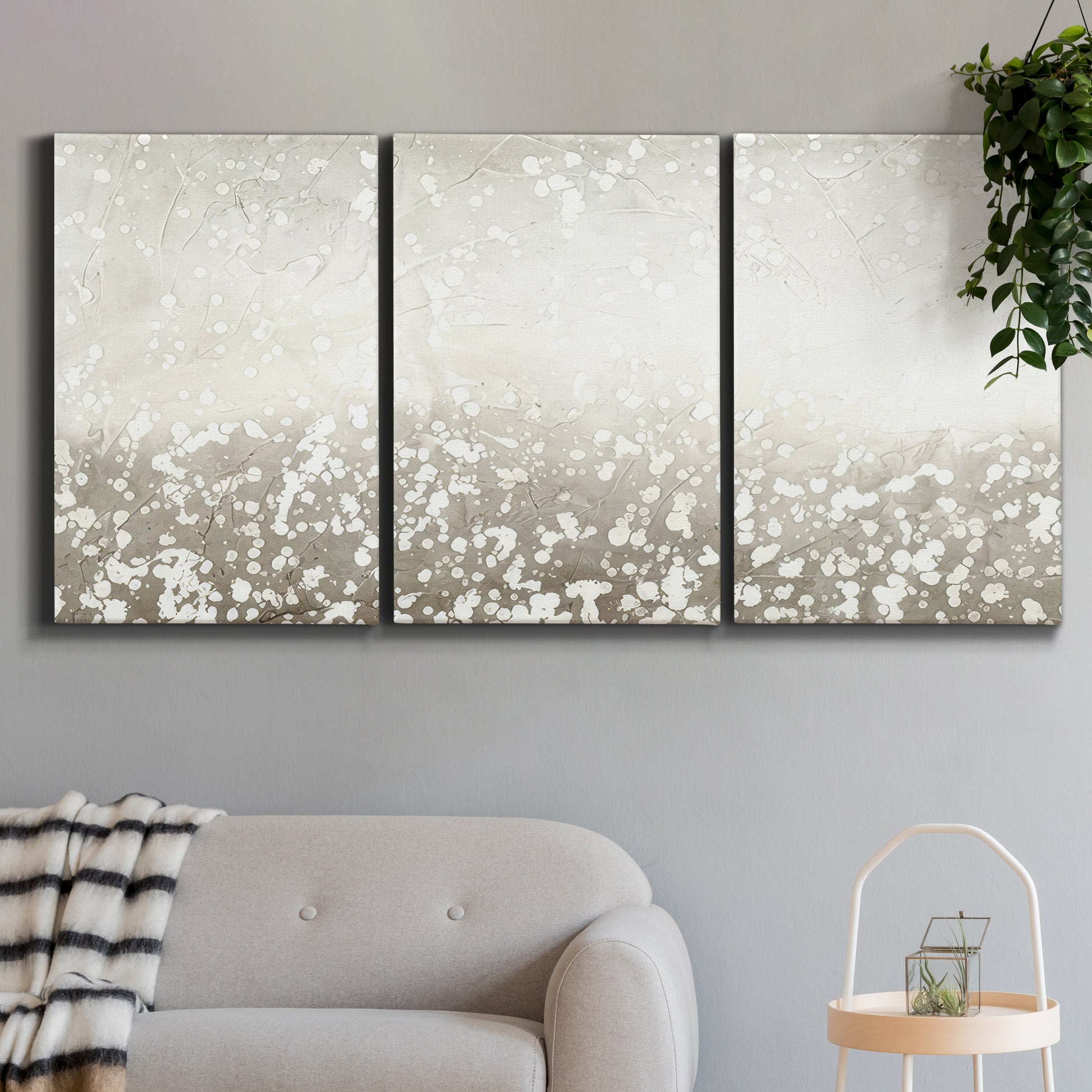 Three-panel canvas wall art featuring dark textured abstract mist, displayed in a modern living room above a sofa.