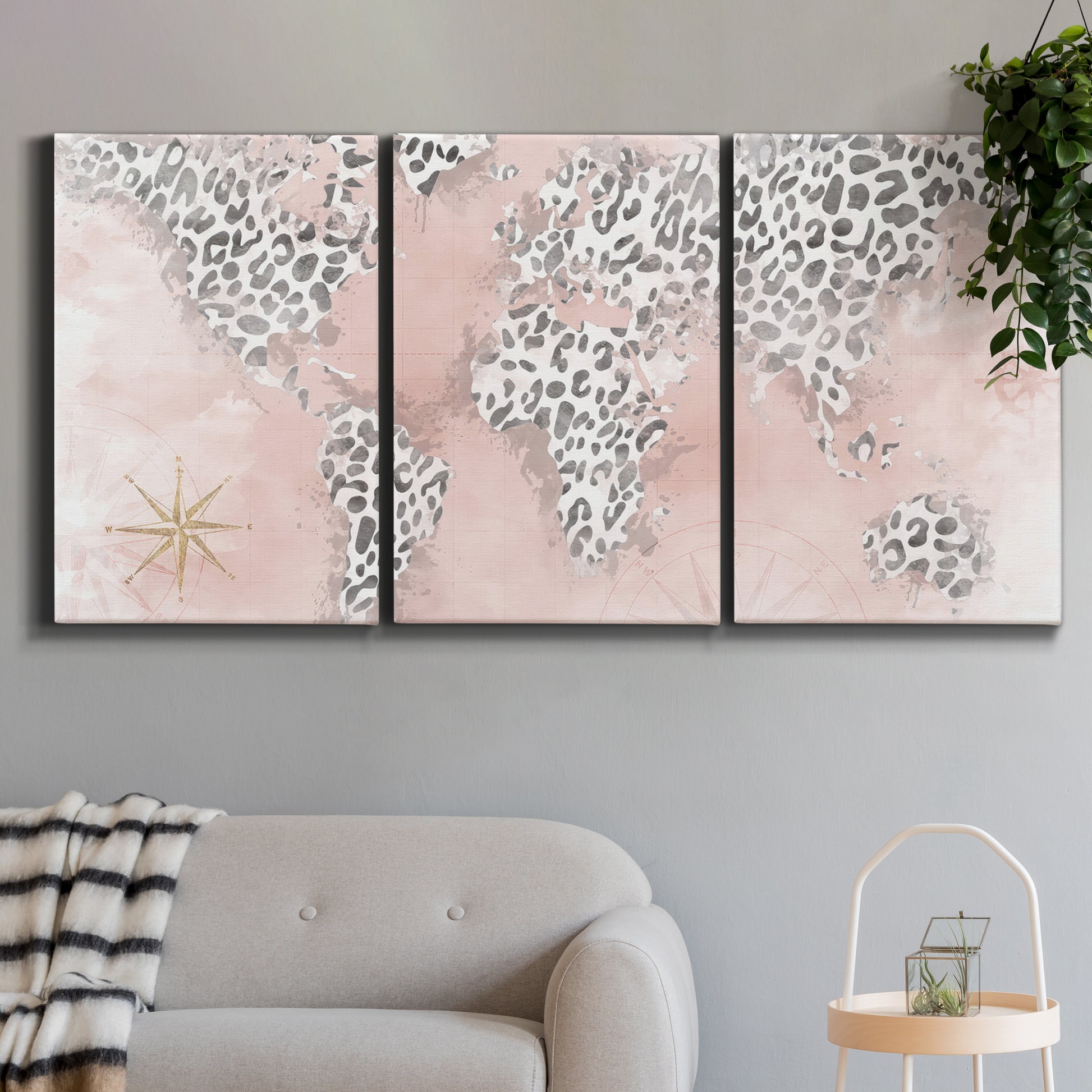 Three-panel canvas wall art featuring stylized pink cheetah world map, displayed in a modern living room above a sofa.