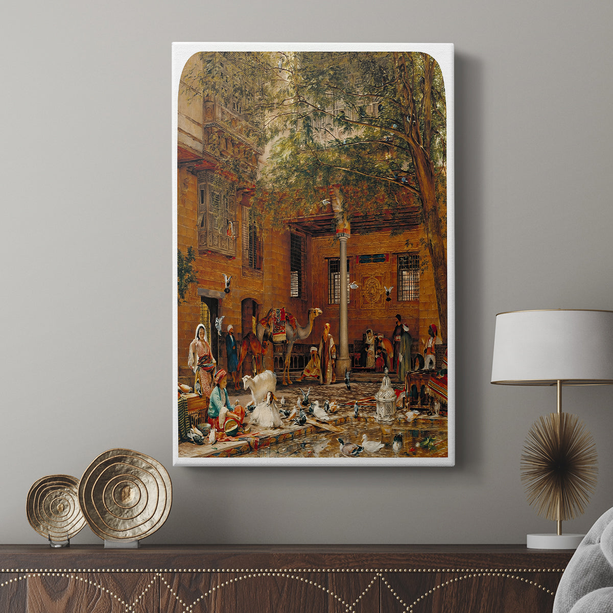 Canvas art print featuring a cultural setting with figures and patterned surroundings displayed in a modern interior space.