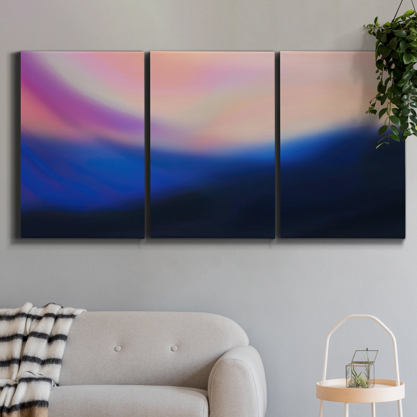 Three-panel canvas wall art featuring smooth abstract sunset color gradient, displayed in a modern living room above a sofa.