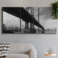 Three-panel canvas wall art featuring manhattan bridge industrial cityscape, displayed in a modern living room above a sofa.