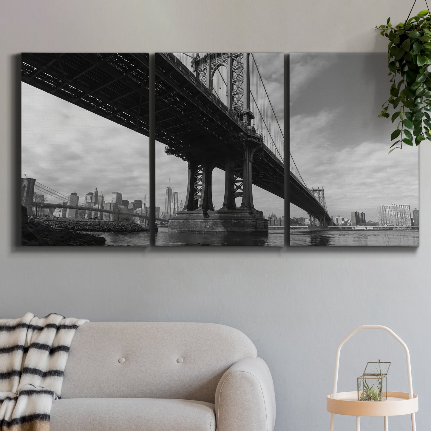Three-panel canvas wall art featuring manhattan bridge industrial cityscape, displayed in a modern living room above a sofa.