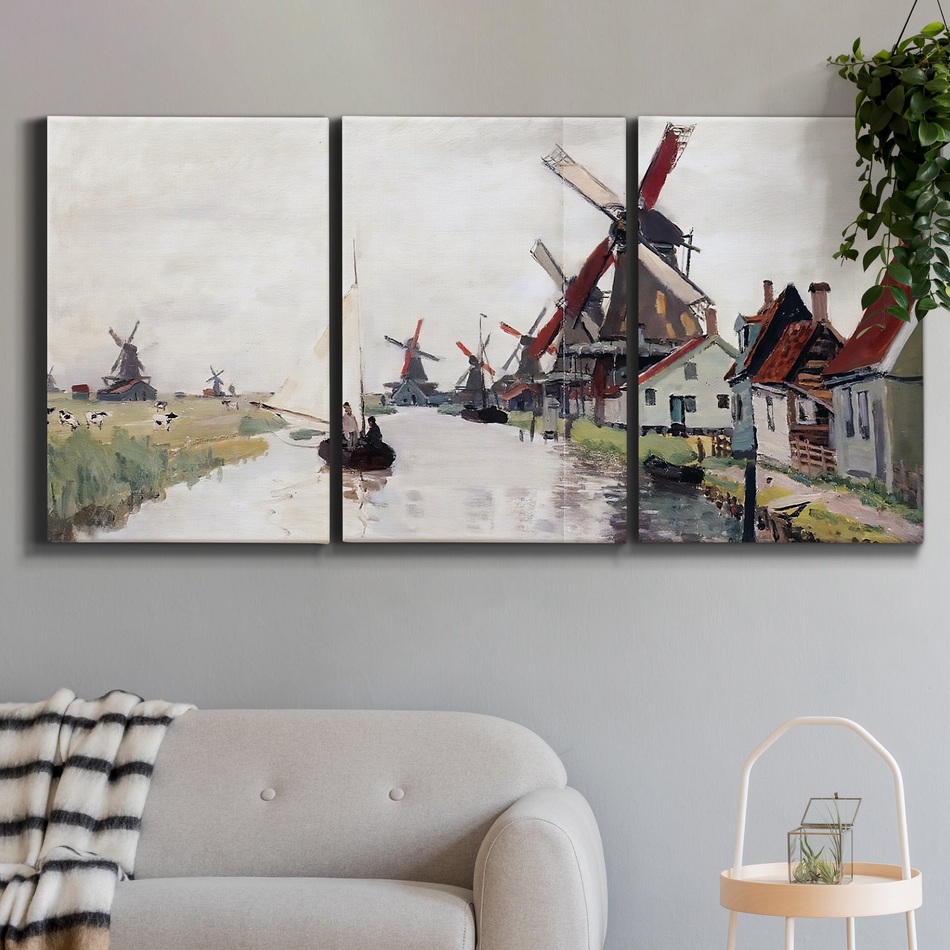 Three-panel canvas wall art featuring windmills beside calm water, displayed in a modern living room above a sofa.