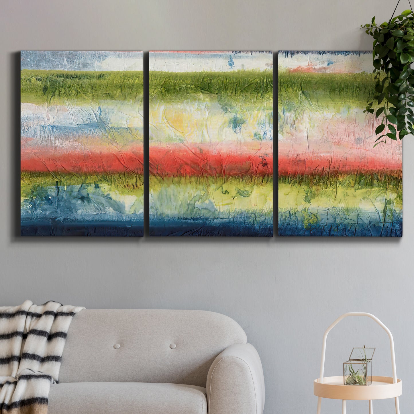 Three-panel canvas wall art featuring layered abstract color banding, displayed in a modern living room above a sofa.
