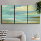 Three-panel canvas wall art featuring calm coastal drift patterns, displayed in a modern living room above a sofa.