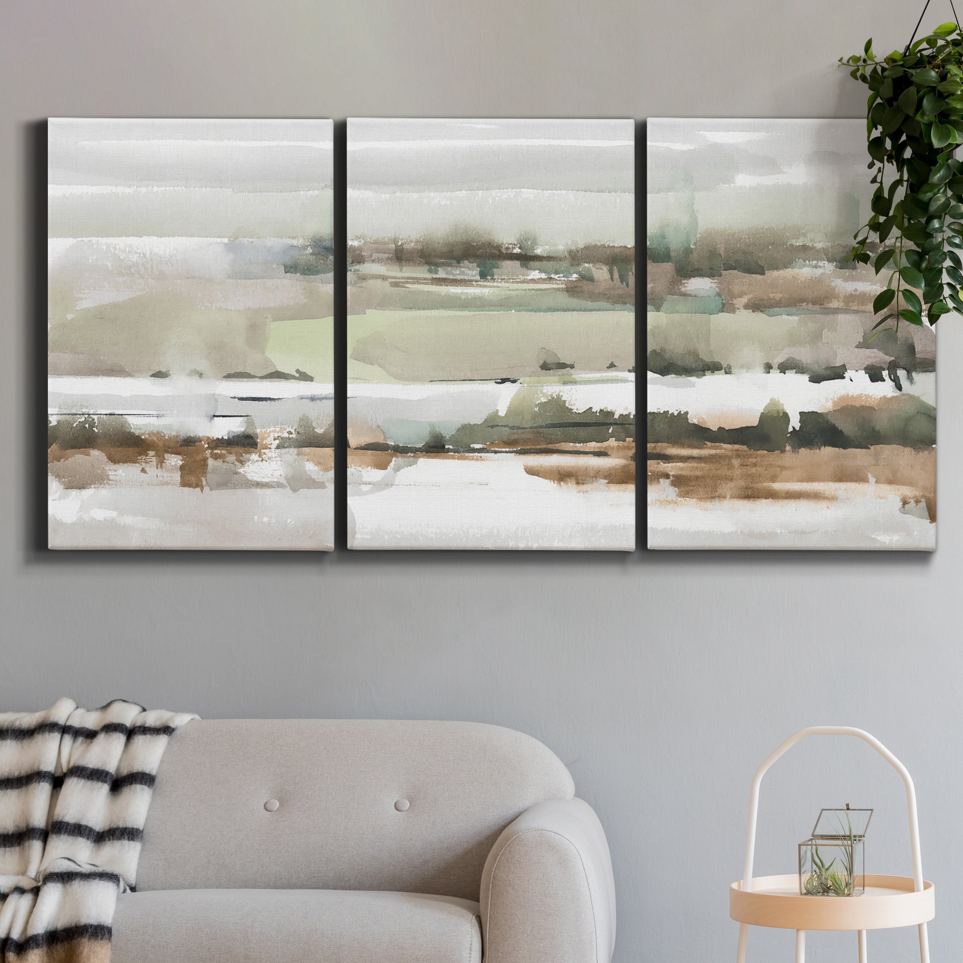 Three-panel canvas wall art featuring layered turquoise and earth tones abstract, displayed in a modern living room above a sofa.