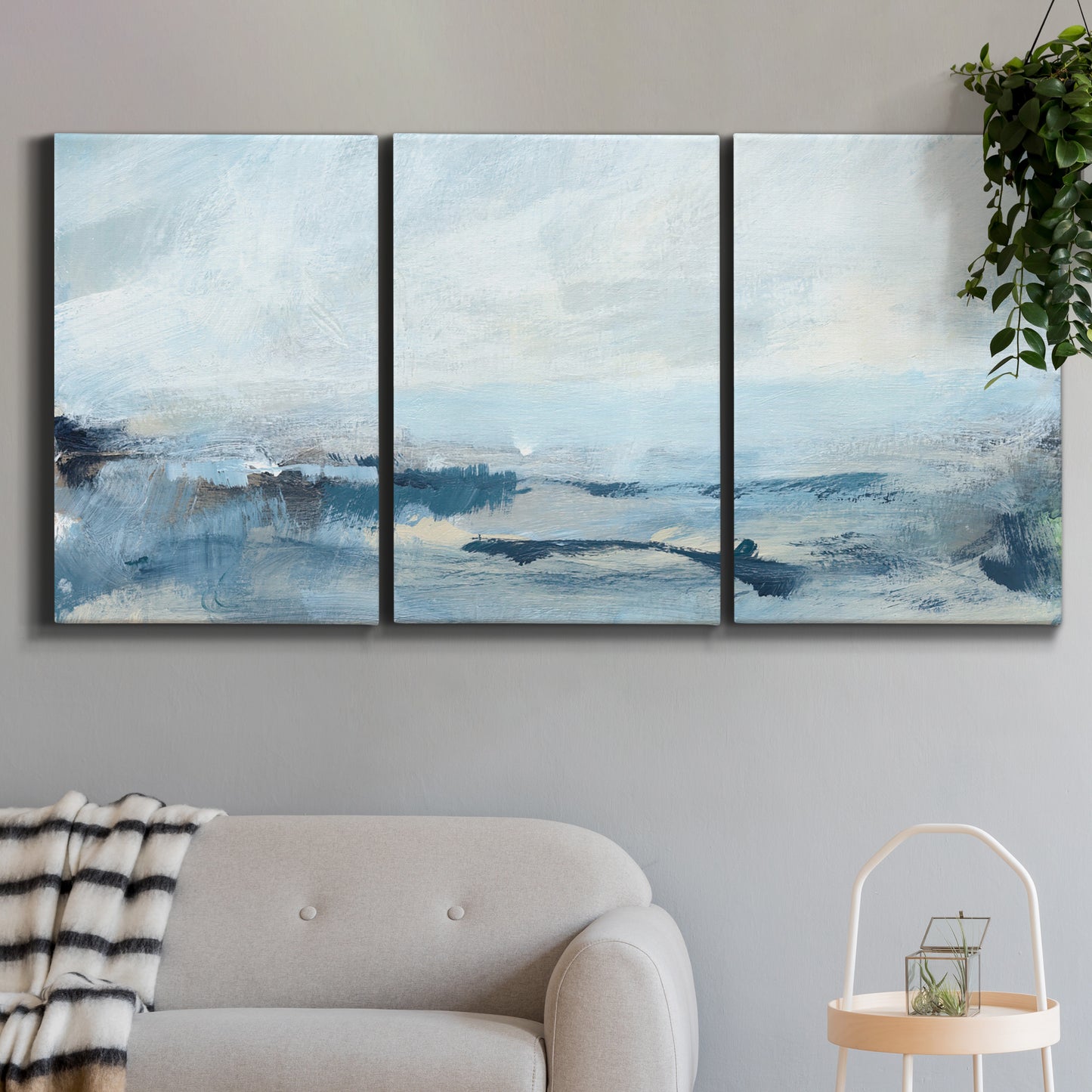 Three-panel canvas wall art featuring abstract sailboats on water, displayed in a modern living room above a sofa.