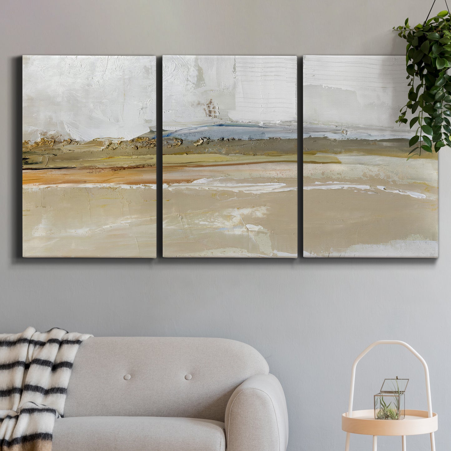 Three-panel canvas wall art featuring golden hour light over landscape, displayed in a modern living room above a sofa.