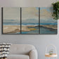 Three-panel canvas wall art featuring abstract coastal landscape, displayed in a modern living room above a sofa.