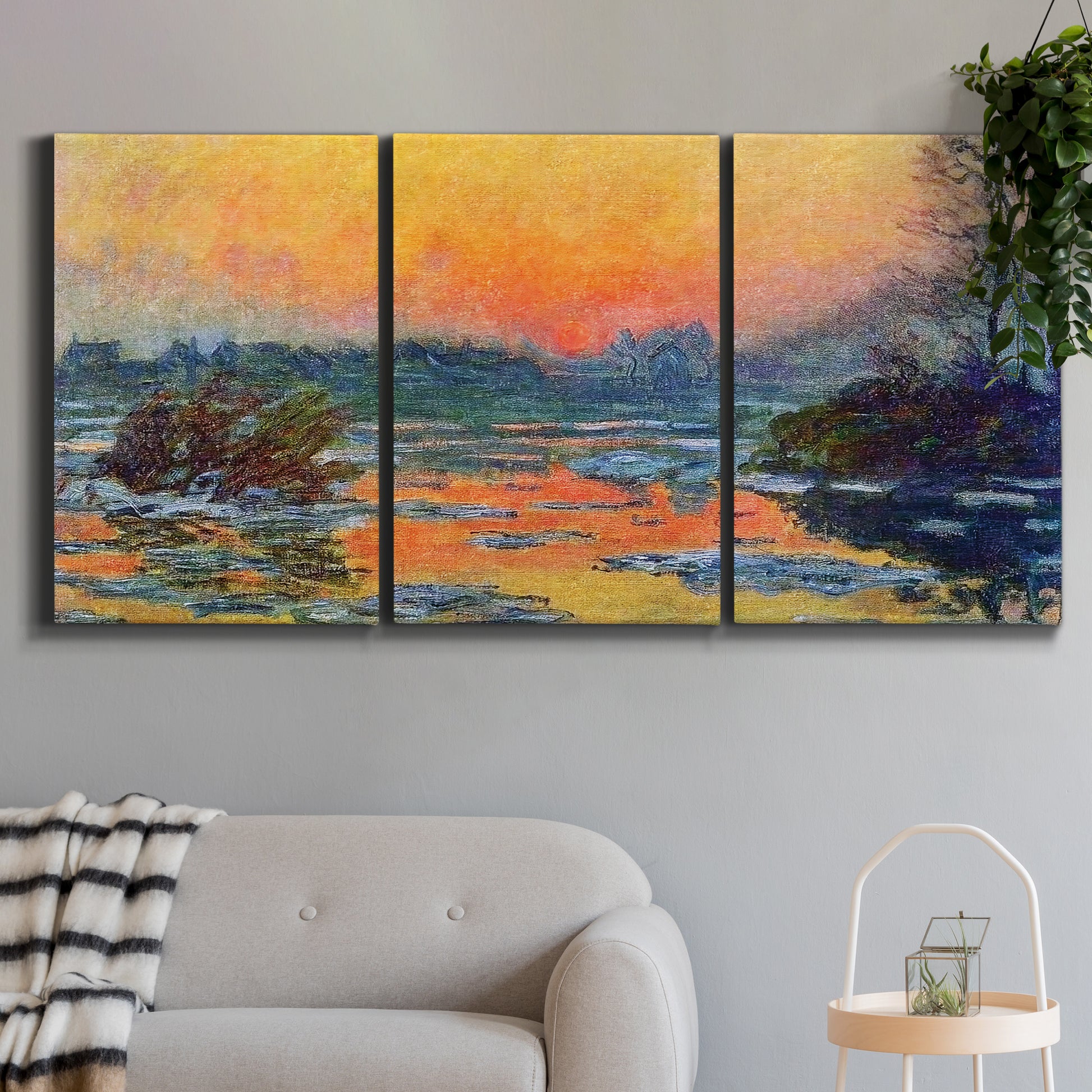 Three-panel canvas wall art featuring winter sunset over river, displayed in a modern living room above a sofa.