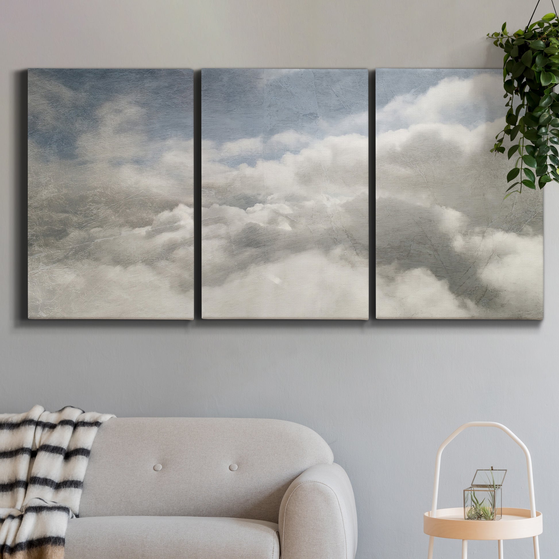Three-panel canvas wall art featuring aerial landscape view photograph, displayed in a modern living room above a sofa.