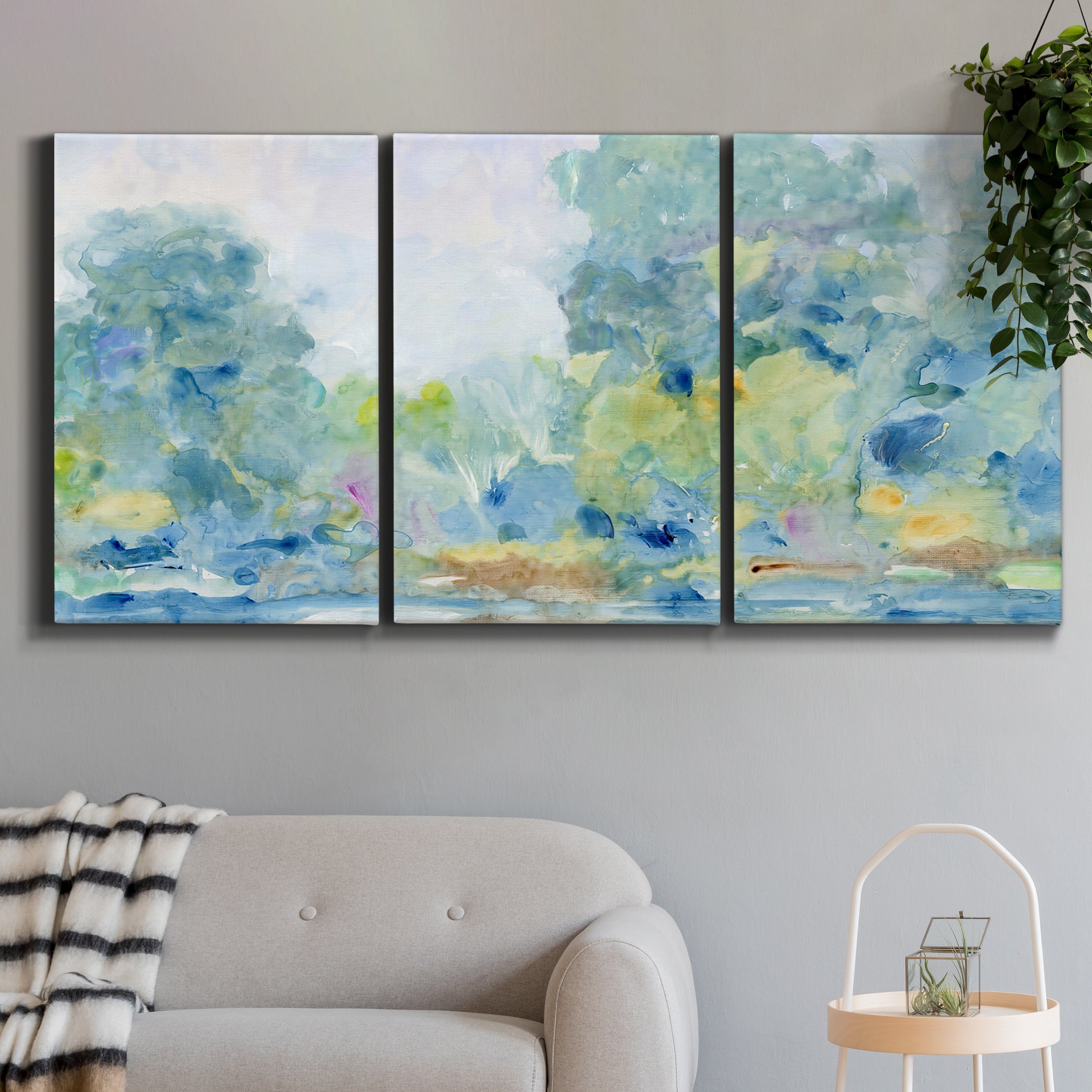 Three-panel canvas wall art featuring quiet abstract morning landscape, displayed in a modern living room above a sofa.