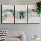 Three-panel canvas wall art featuring abstract mountain range watercolor, displayed in a modern living room above a sofa.
