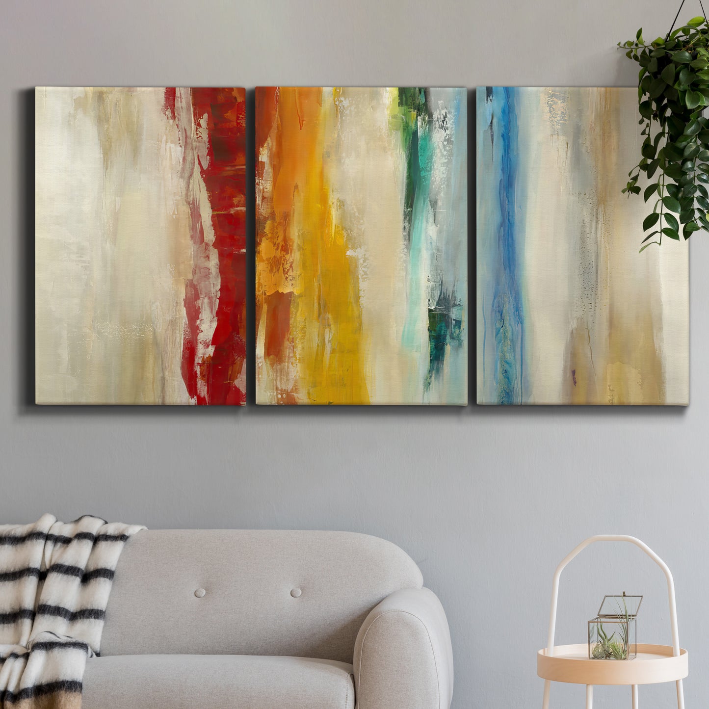 Three-panel canvas wall art featuring abstract divided color hemisphere forms, displayed in a modern living room above a sofa.