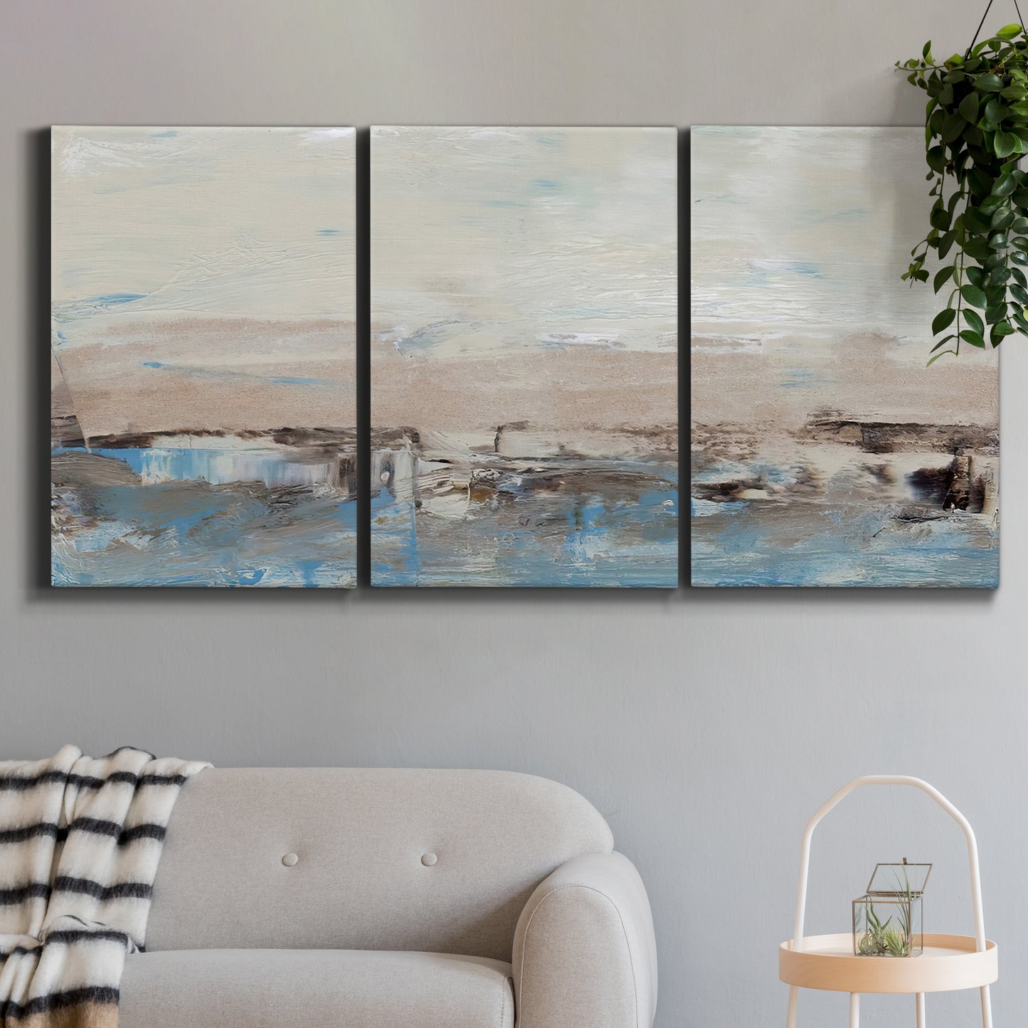 Three-panel canvas wall art featuring abstract bridge landscape in cyan, displayed in a modern living room above a sofa.