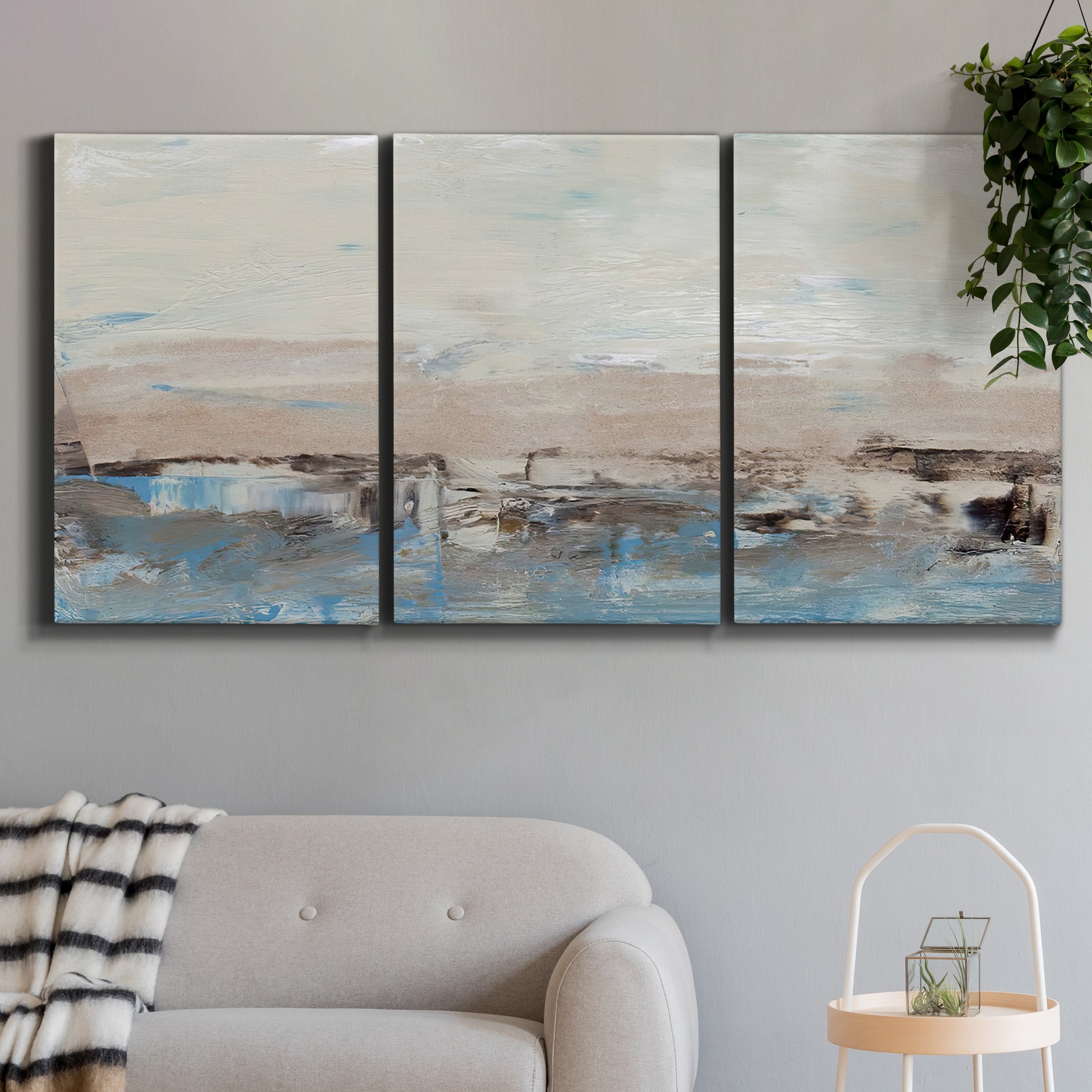 Three-panel canvas wall art featuring abstract bridge landscape in cyan, displayed in a modern living room above a sofa.