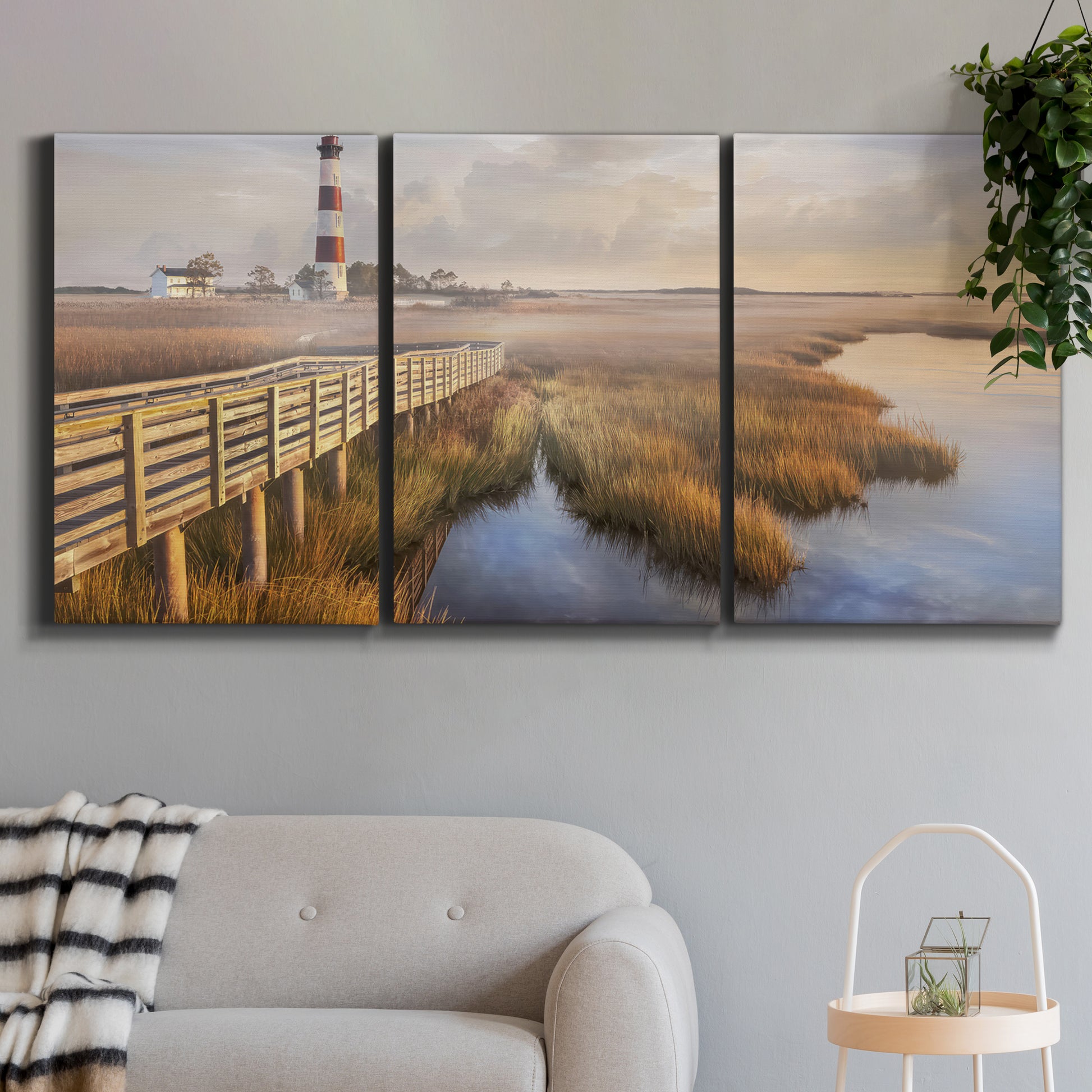Three-panel canvas wall art featuring coastal path along dunes, displayed in a modern living room above a sofa.