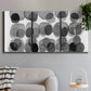 Three-panel canvas wall art featuring geometric abstract watercolor forms, displayed in a modern living room above a sofa.