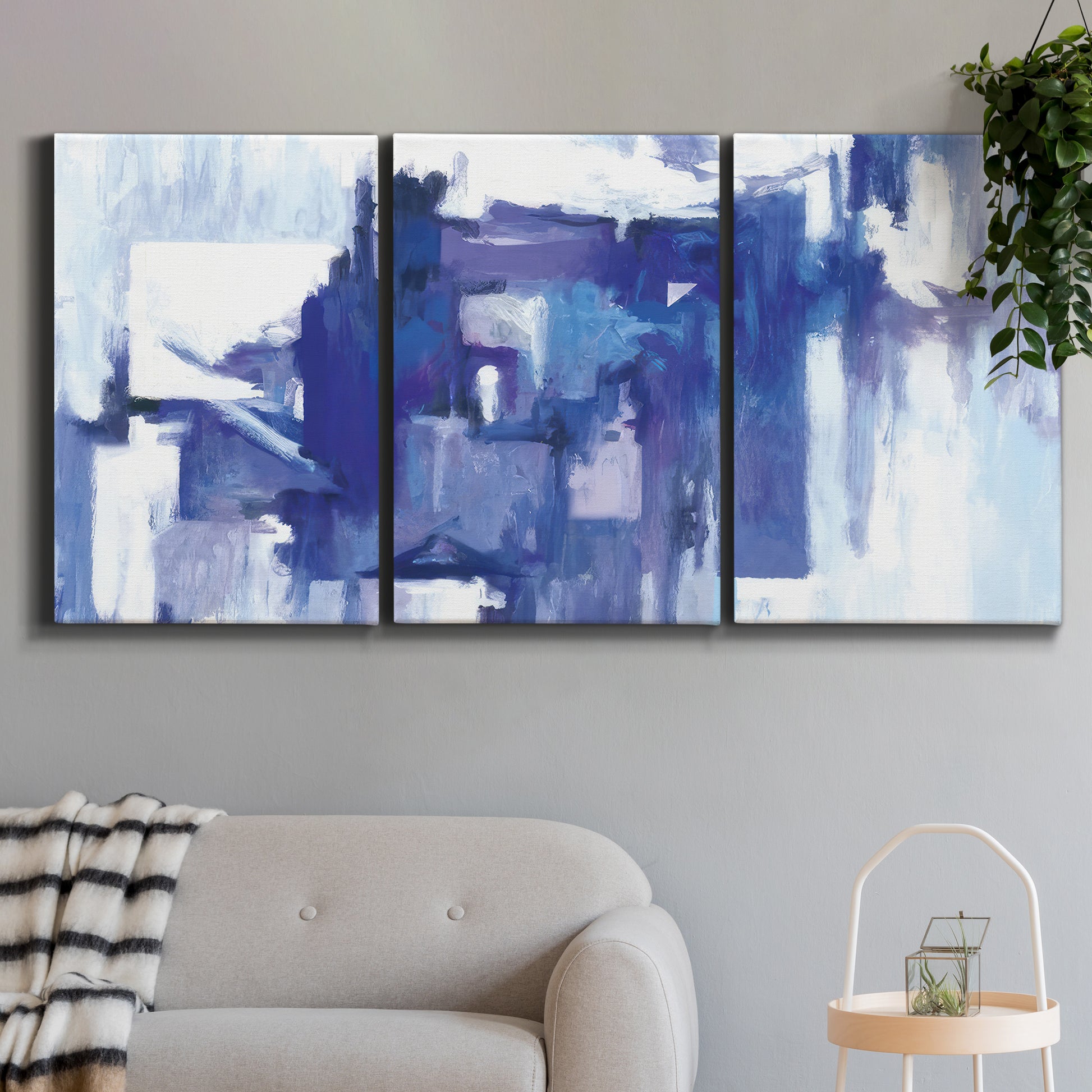 Three-panel canvas wall art featuring abstract urban street scene, displayed in a modern living room above a sofa.