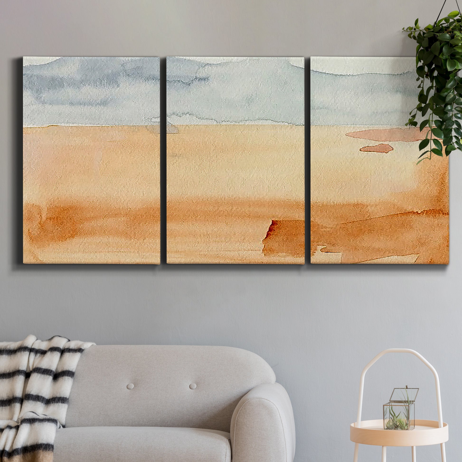 Three-panel canvas wall art featuring minimal horizon with soft blue tones, displayed in a modern living room above a sofa.