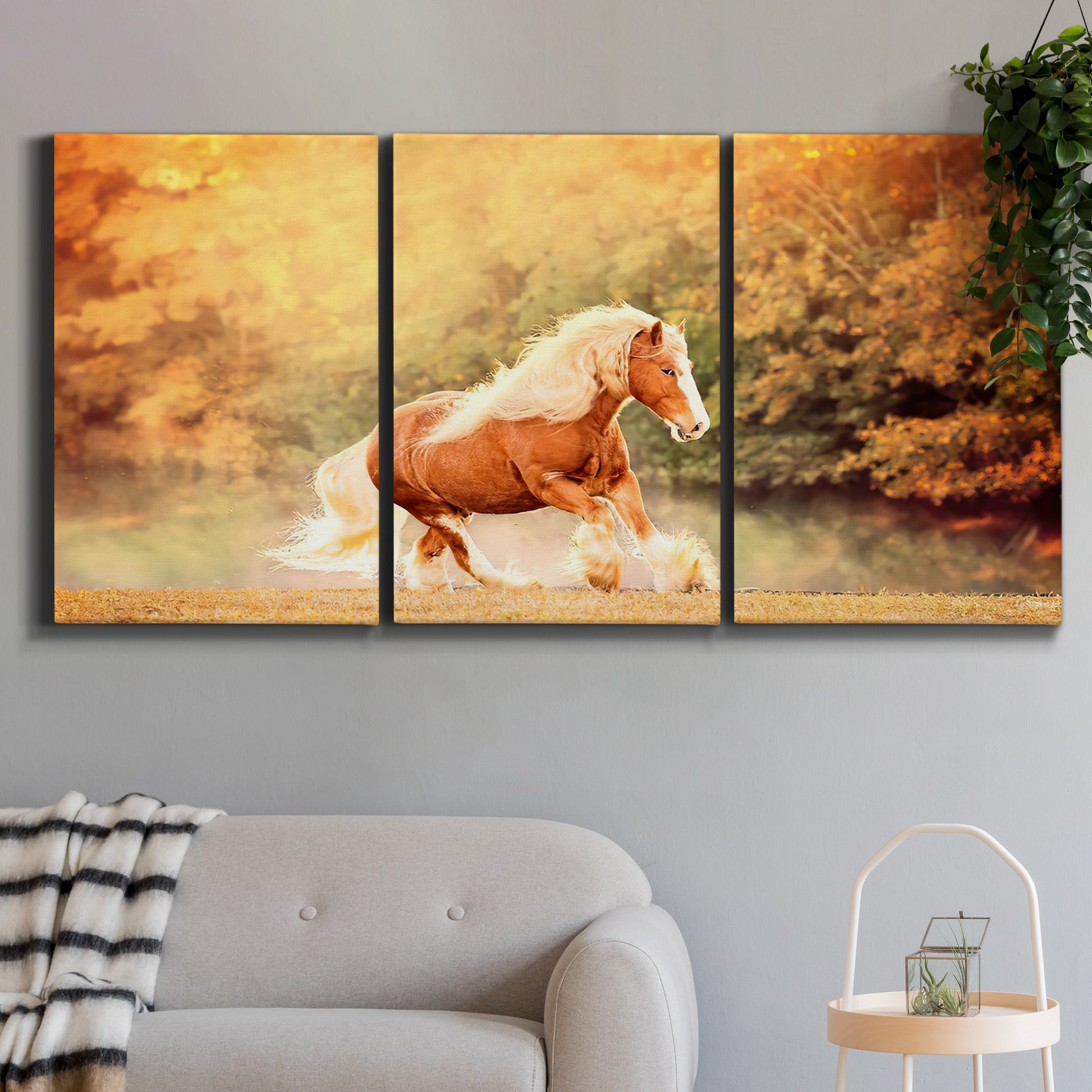 Three-panel canvas wall art featuring running horses captured in motion, displayed in a modern living room above a sofa.