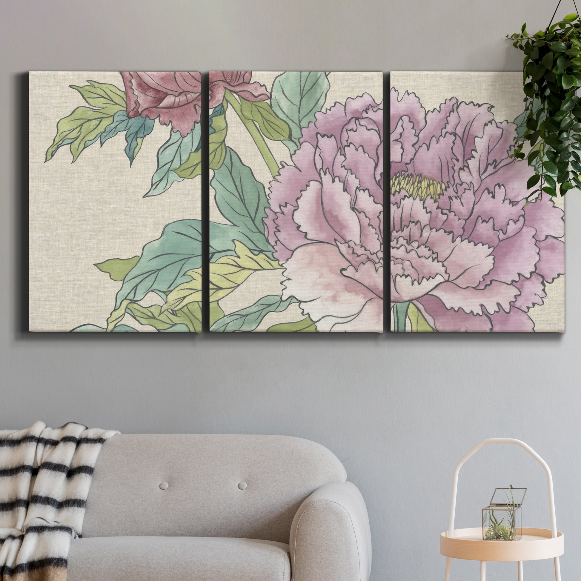 Three-panel canvas wall art featuring soft pink peony blossoms, displayed in a modern living room above a sofa.