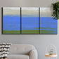 Three-panel canvas wall art featuring abstract coastal inlet landscape, displayed in a modern living room above a sofa.