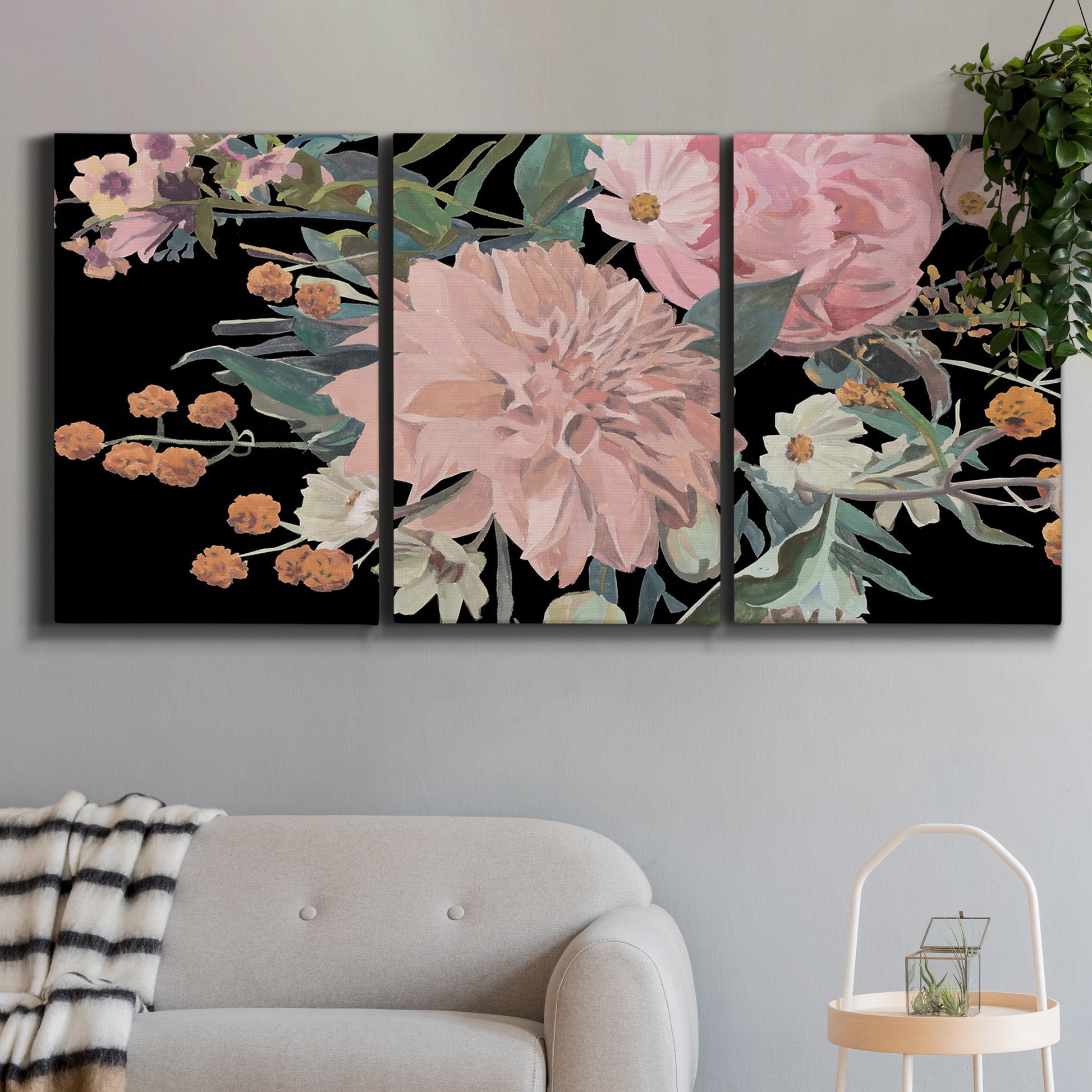 Three-panel canvas wall art featuring dark floral night blossoms, displayed in a modern living room above a sofa.
