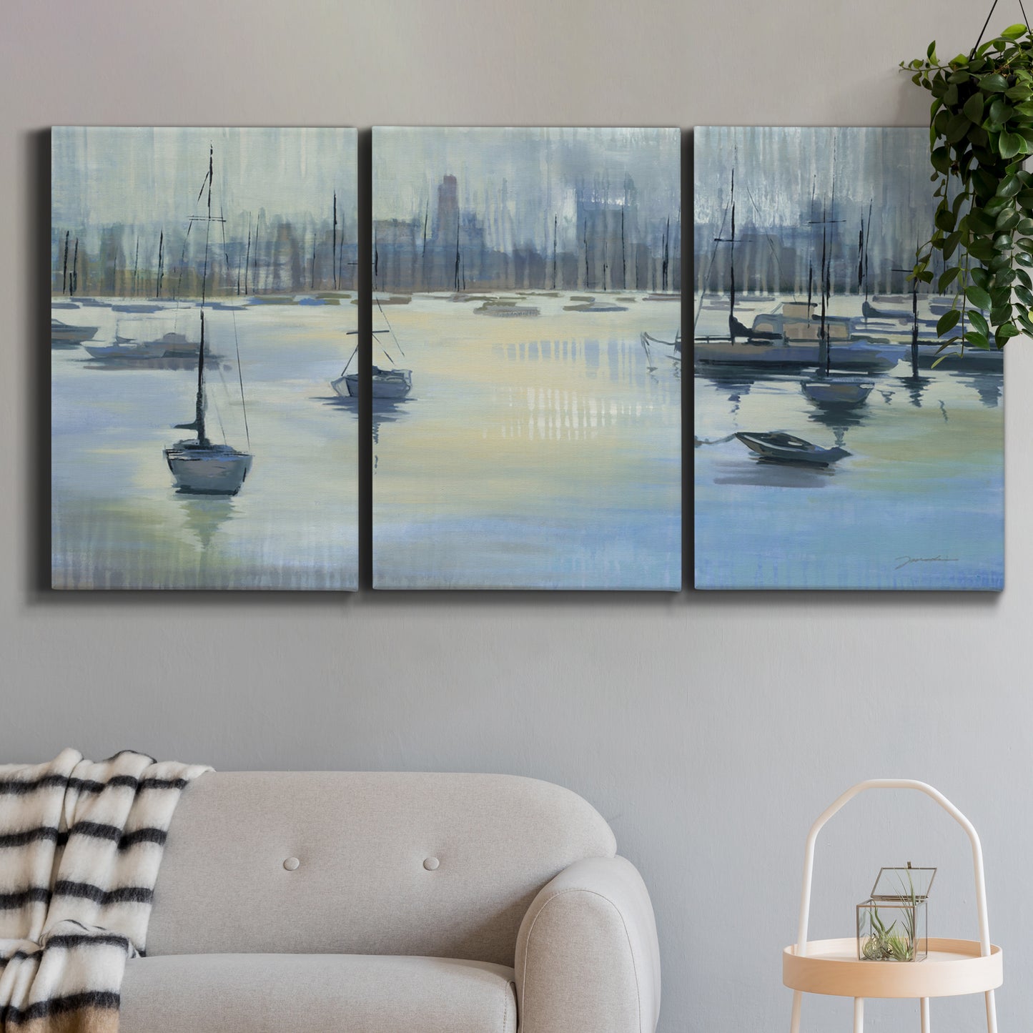 Three-panel canvas wall art featuring anchored boats near shoreline, displayed in a modern living room above a sofa.
