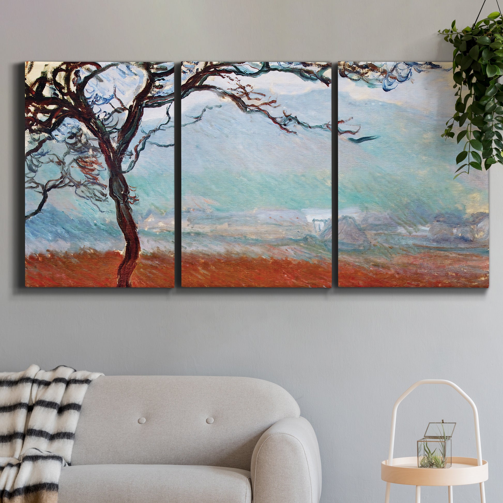 Three-panel canvas wall art featuring coastal trees at evening light, displayed in a modern living room above a sofa.