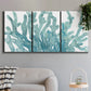 Three-panel canvas wall art featuring blue coral inspired watercolor, displayed in a modern living room above a sofa.