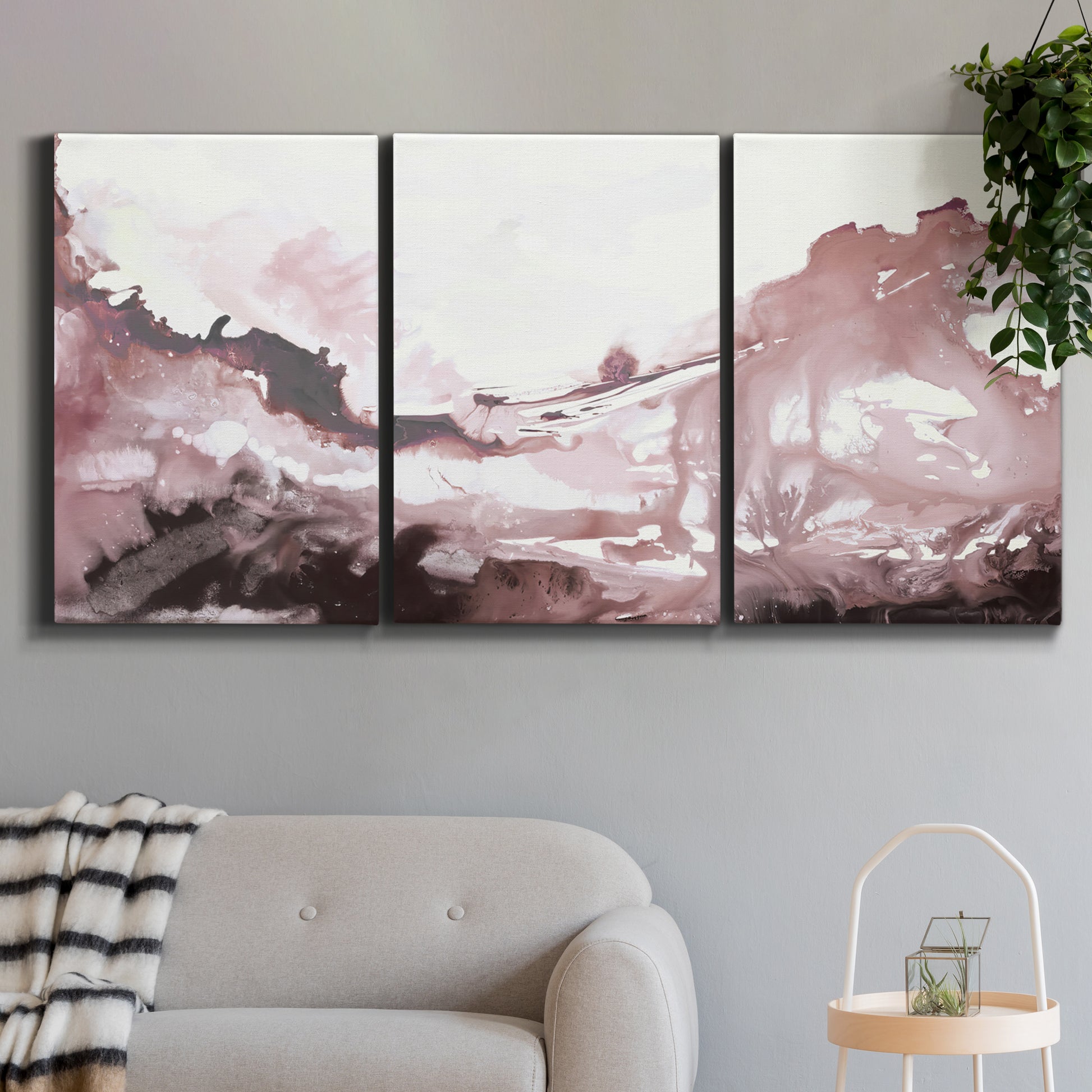 Three-panel canvas wall art featuring soft pink abstract scenic layers, displayed in a modern living room above a sofa.