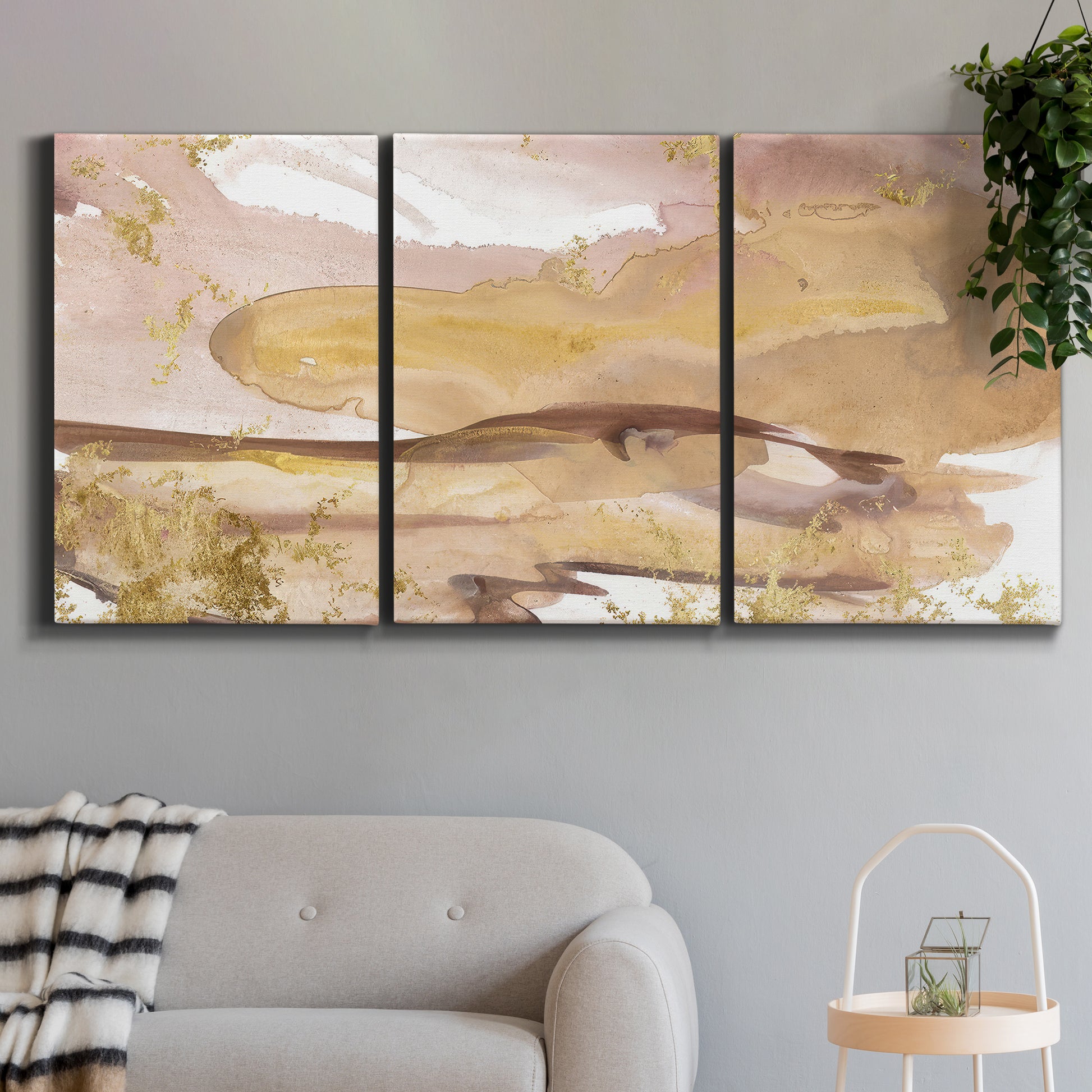 Three-panel canvas wall art featuring layered abstract dawn tones, displayed in a modern living room above a sofa.