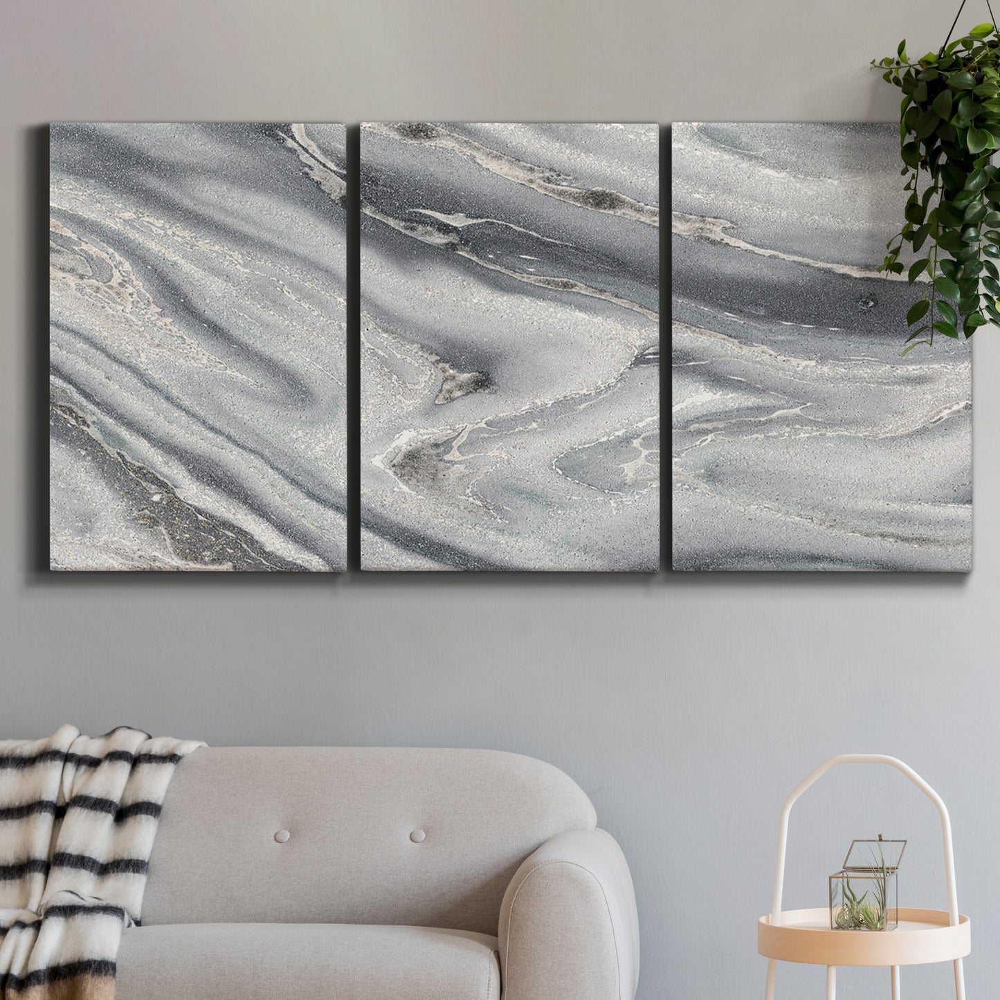 Three-panel canvas wall art featuring minimal monochrome abstract forms, displayed in a modern living room above a sofa.