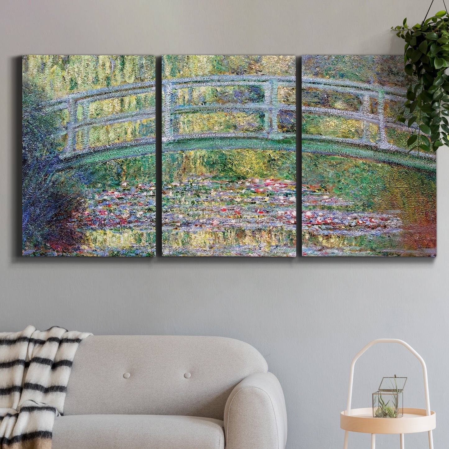 Three-panel canvas wall art featuring water lilies with arched bridge, displayed in a modern living room above a sofa.