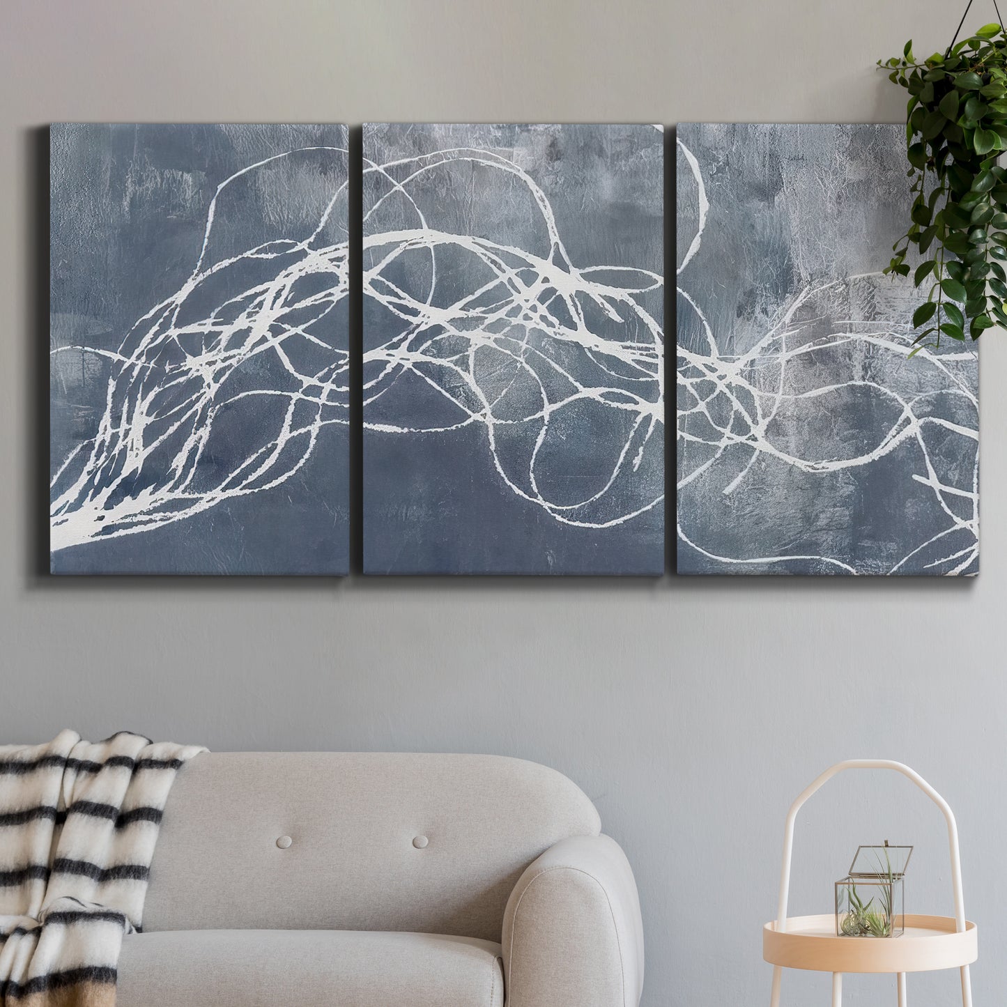 Three-panel canvas wall art featuring coastal shoreline at golden hour, displayed in a modern living room above a sofa.