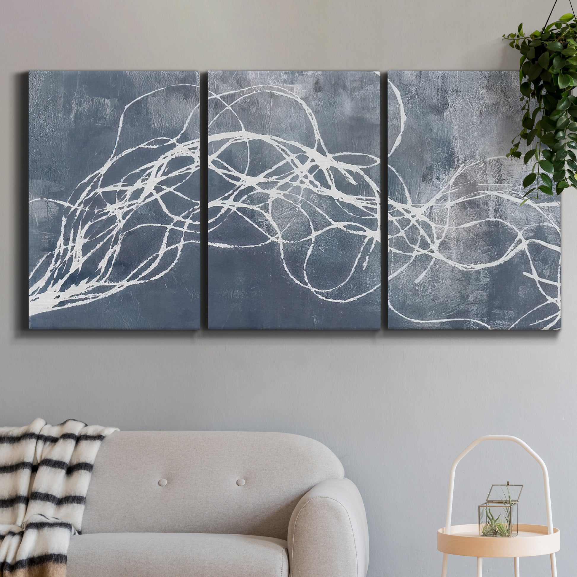 Three-panel canvas wall art featuring coastal shoreline at golden hour, displayed in a modern living room above a sofa.
