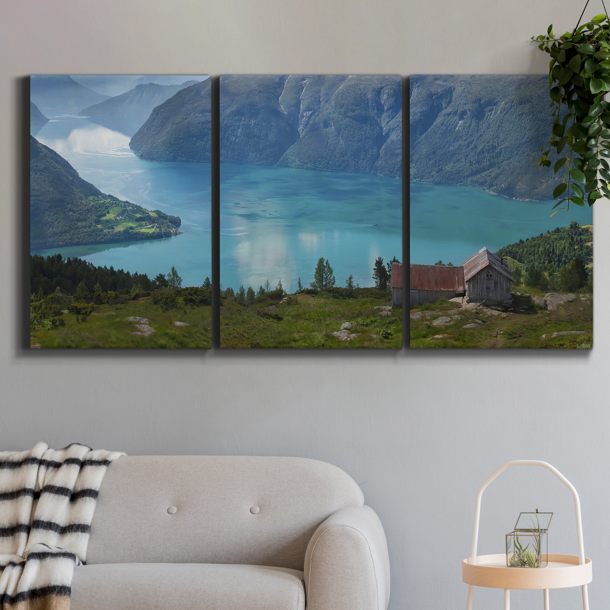 Three-panel canvas wall art featuring symmetrical water reflections with trees, displayed in a modern living room above a sofa.