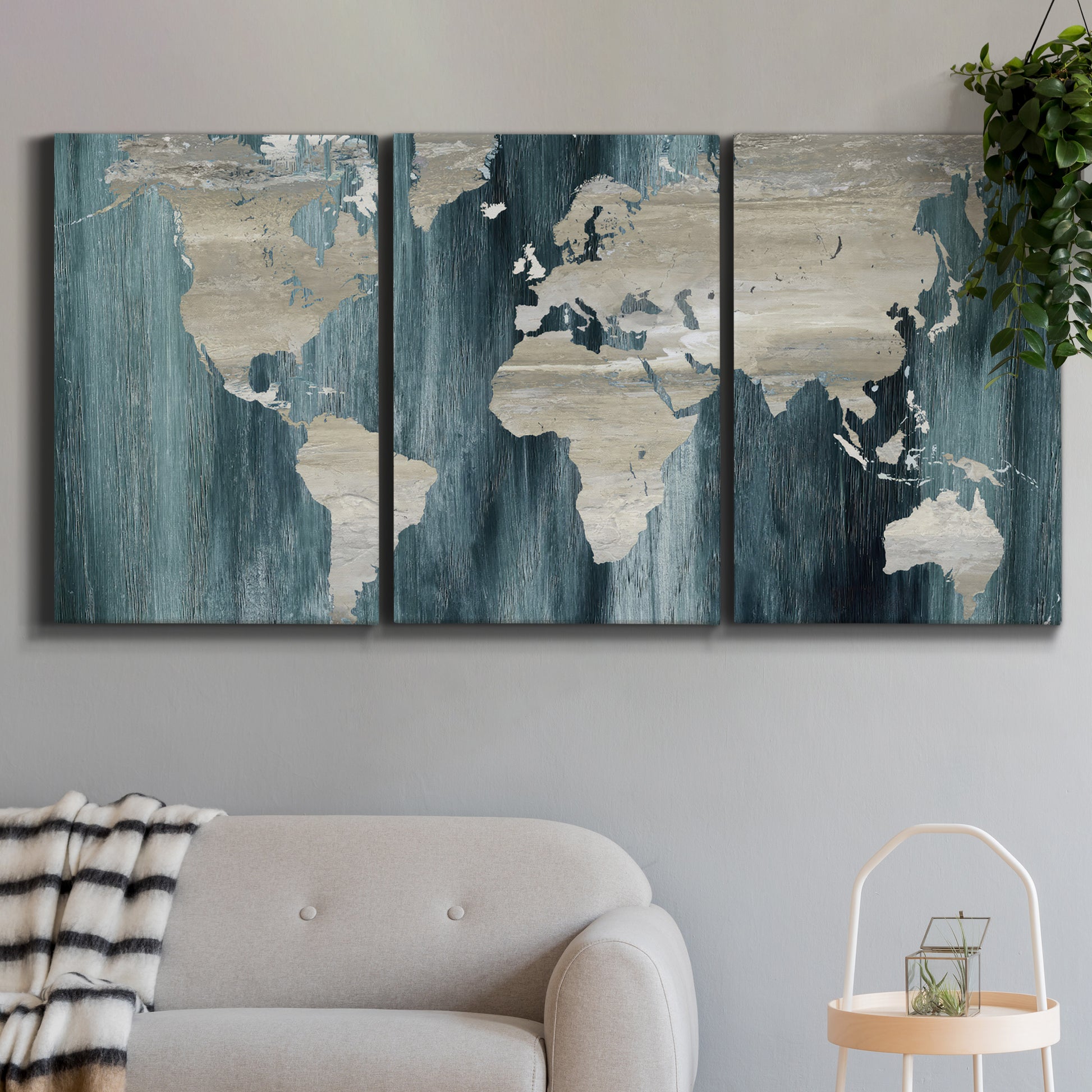 Three-panel canvas wall art featuring golden coastal sunset with cliffs, displayed in a modern living room above a sofa.