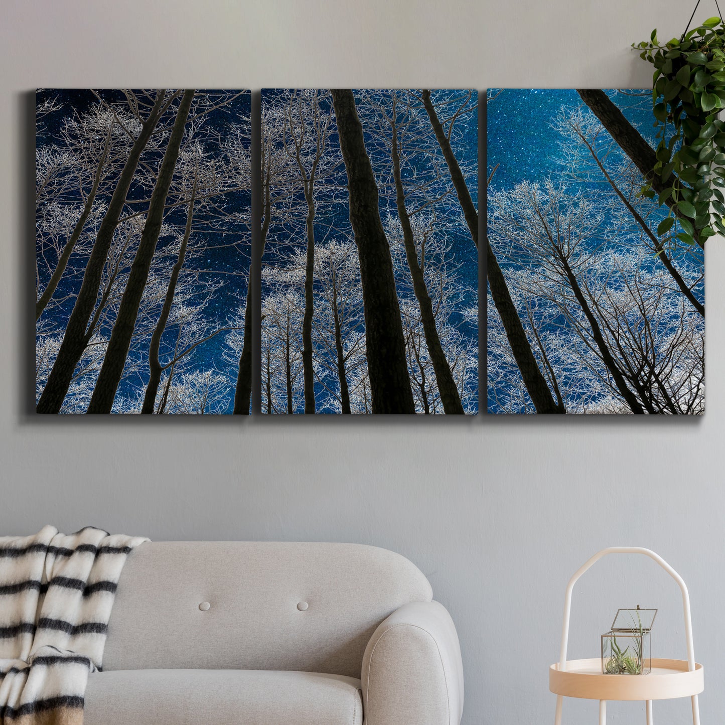 Three-panel canvas wall art featuring night landscape silhouette photography, displayed in a modern living room above a sofa.