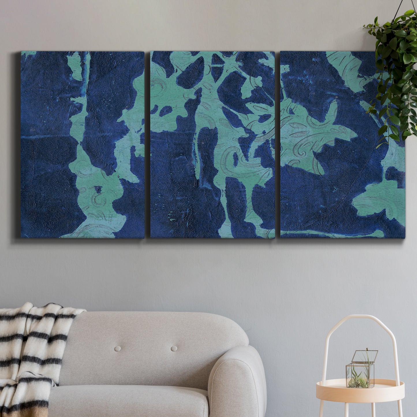 Three-panel canvas wall art featuring abstract floral shapes, displayed in a modern living room above a sofa.