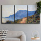 Three-panel canvas wall art featuring winding coastal road above sea, displayed in a modern living room above a sofa.