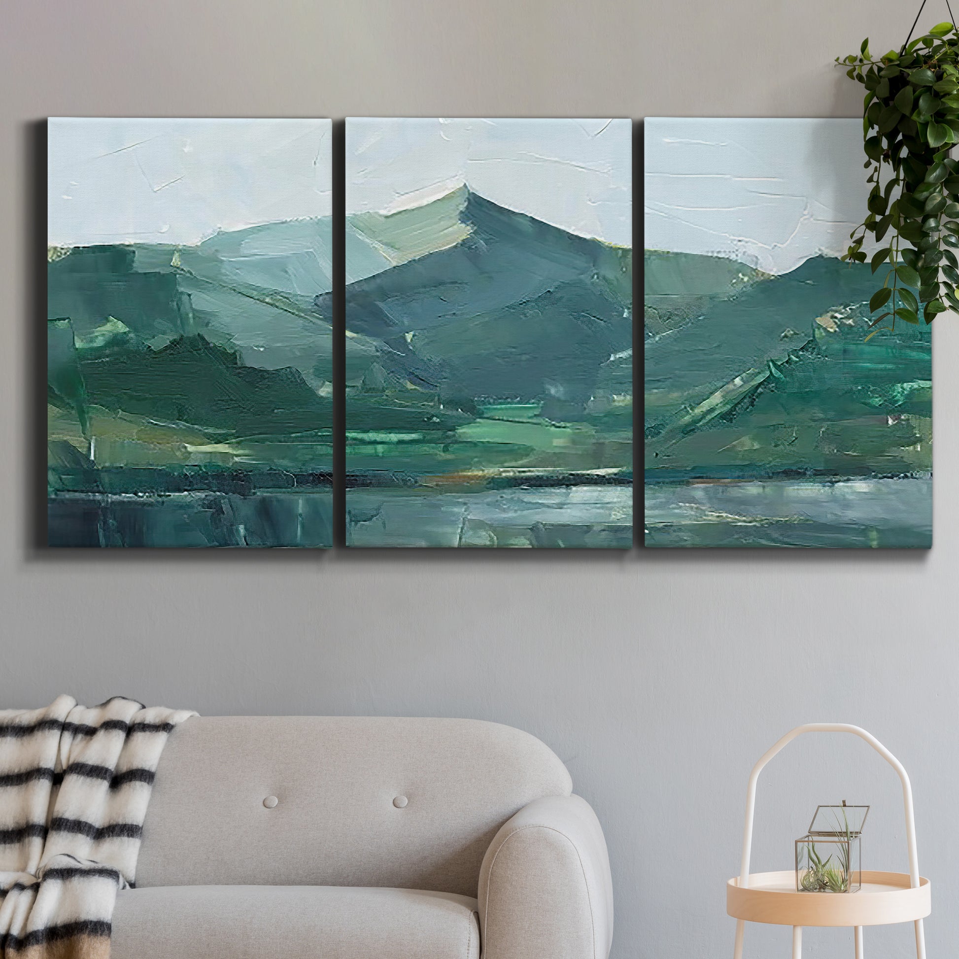 Three-panel canvas wall art featuring muted mountain range in grey tones, displayed in a modern living room above a sofa.