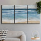 Three-panel canvas wall art featuring rolling ocean waves near shore, displayed in a modern living room above a sofa.